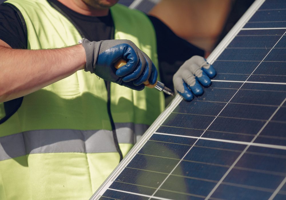 Engineer in a white helmet. Man near solar panel.