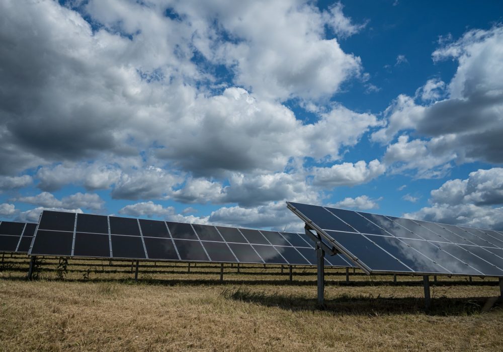 The solar panels used for renewable energy on the field under the sky full of clouds